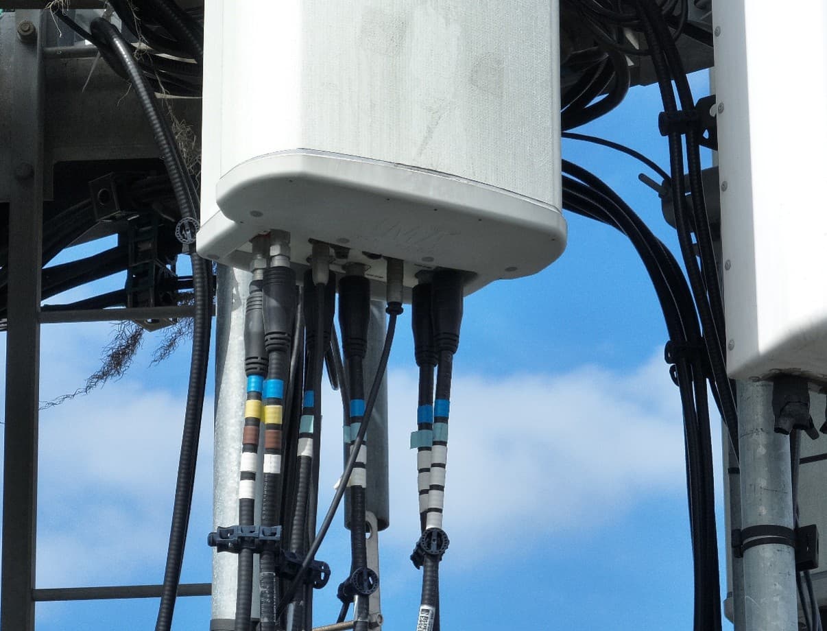 Gros plan d'une antenne télécom et de ses raccordements câbles — audit haute résolution au drone